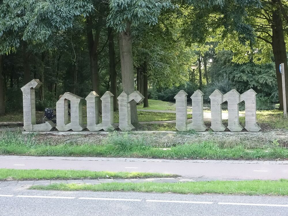 Groot houten lettersculptuur Laur um tussen de bomen in het Brediuspark in Woerden